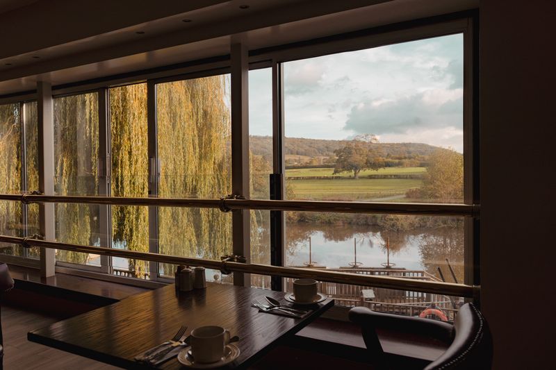 View of the River Avon and willow trees from a dining table at The Avon and Ember